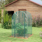 Cage fruitière verte avec plantes près d’un abri en bois