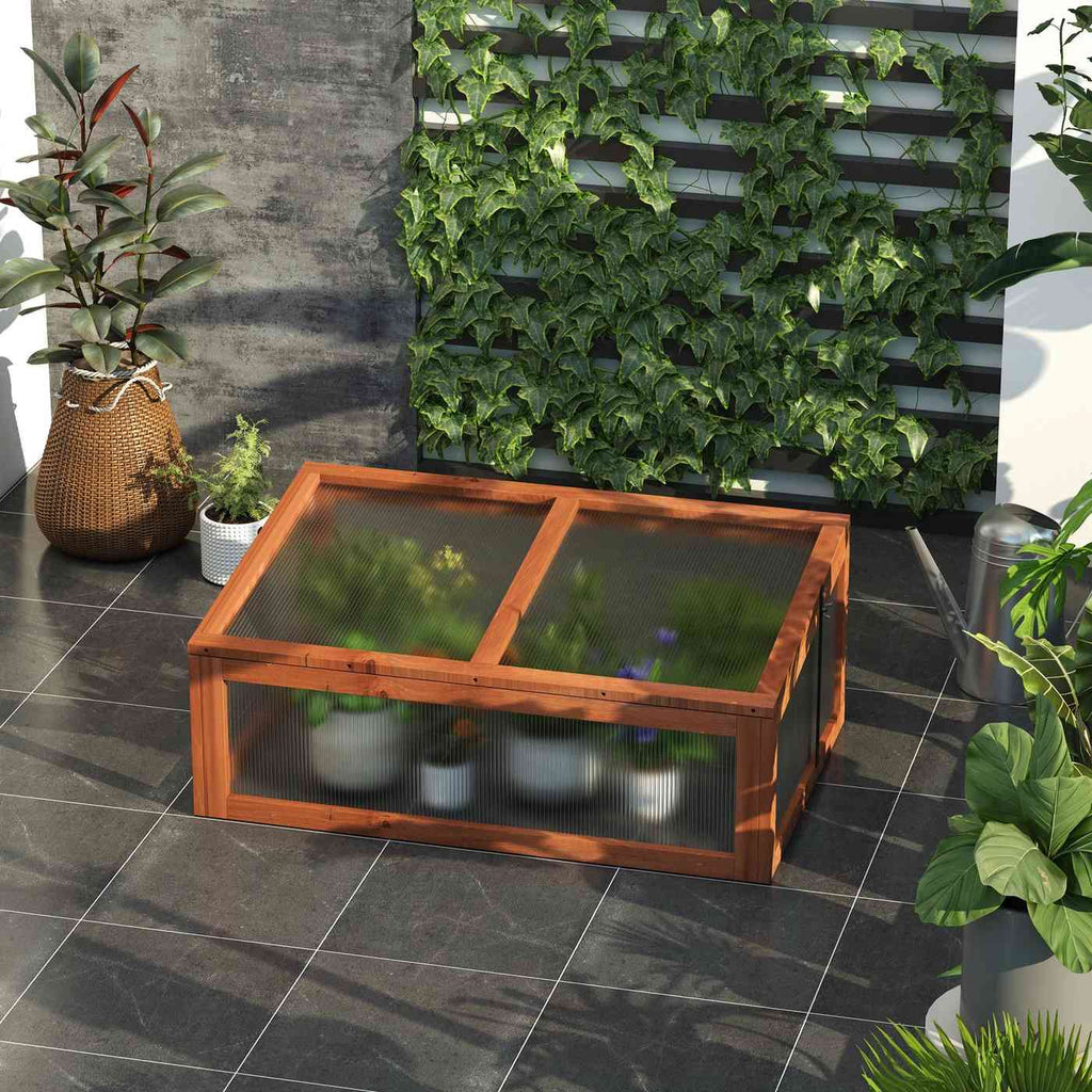 Châssis brun garni de plantes sur une terrasse en dalles