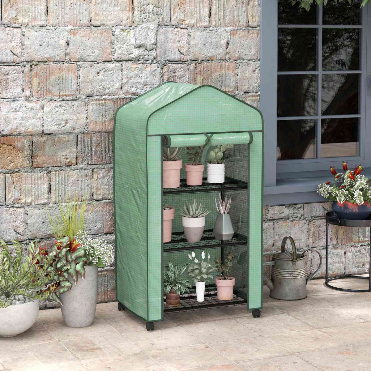 Mini serre verte avec plantes devant un mur en pierres