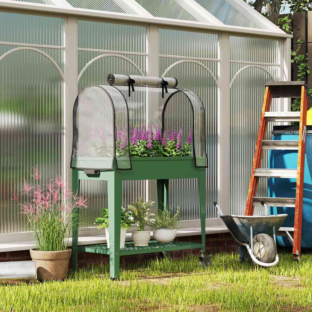 Bac potager vert avec serre et fleurs près d’une grande serre de jardin
