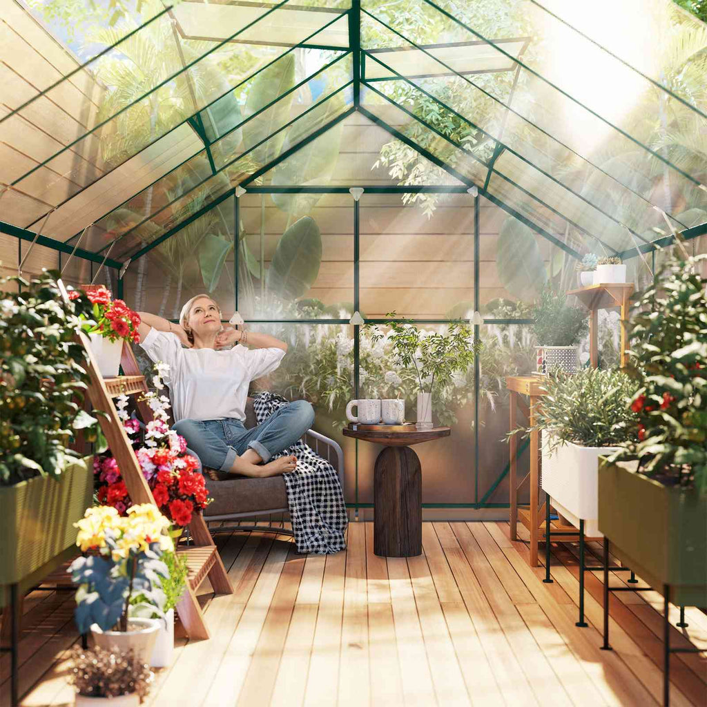 Personne assise parmi les plantes à l’intérieur de la serre verte