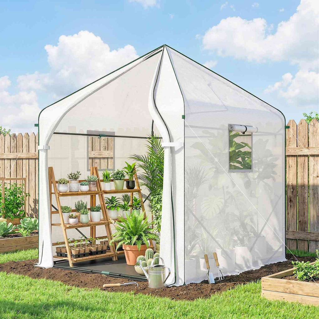 Serre blanche avec étagère de plantes dans le jardin