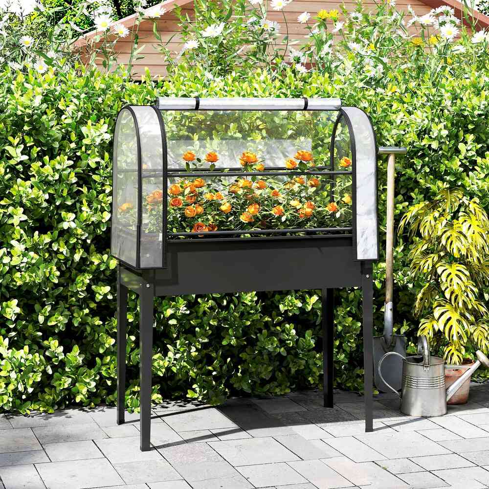 Bac potager noir sur pieds avec serre et fleurs dans le jardin