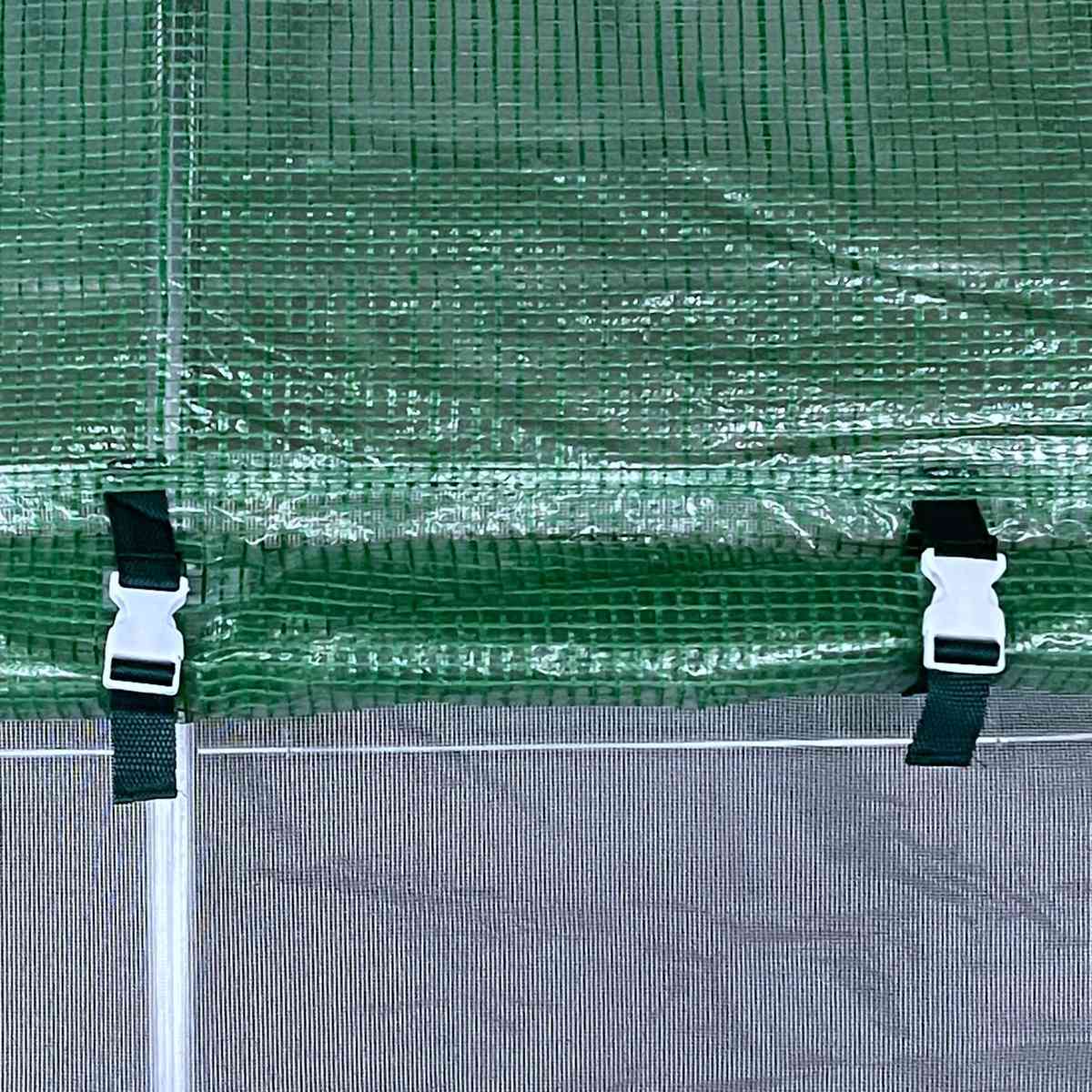 Fenêtre moustiquaire de la serre avec volet vert et attaches à boucle