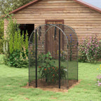 Cage fruitière noire avec plantes près d’un abri en bois