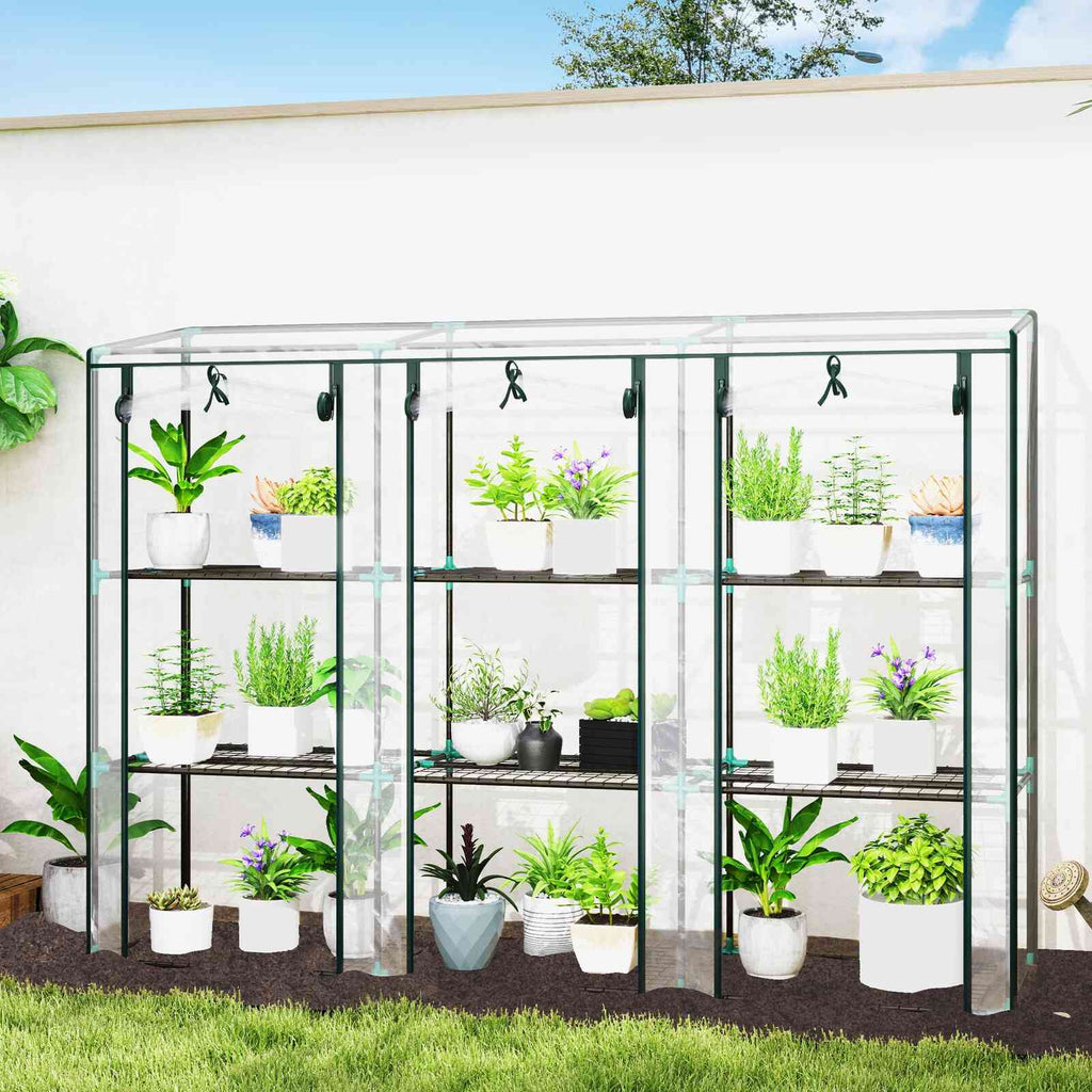 Serre de balcon transparente remplie de plantes devant un mur blanc
