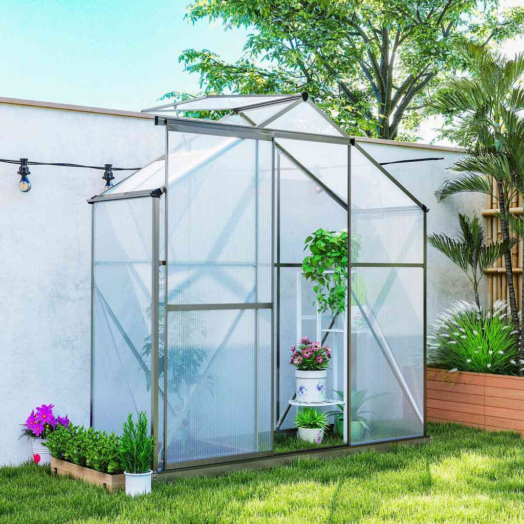 Serre étroite à structure grise et porte ouverte dans un jardin