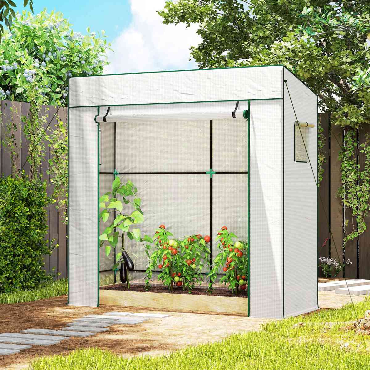 Serre blanche avec légumes près d’une allée de jardin