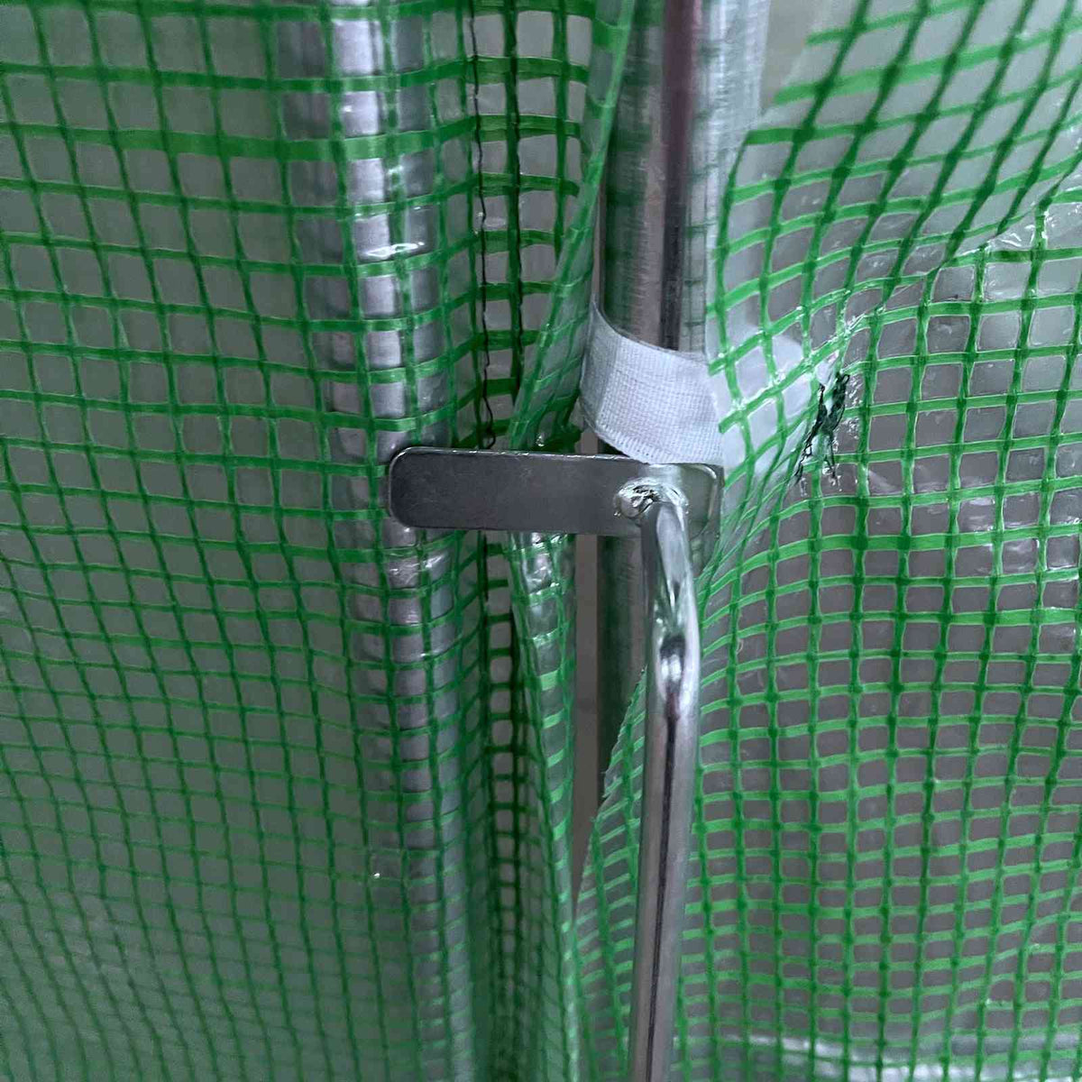 Poignée métallique de la porte battante de la serre tunnel verte