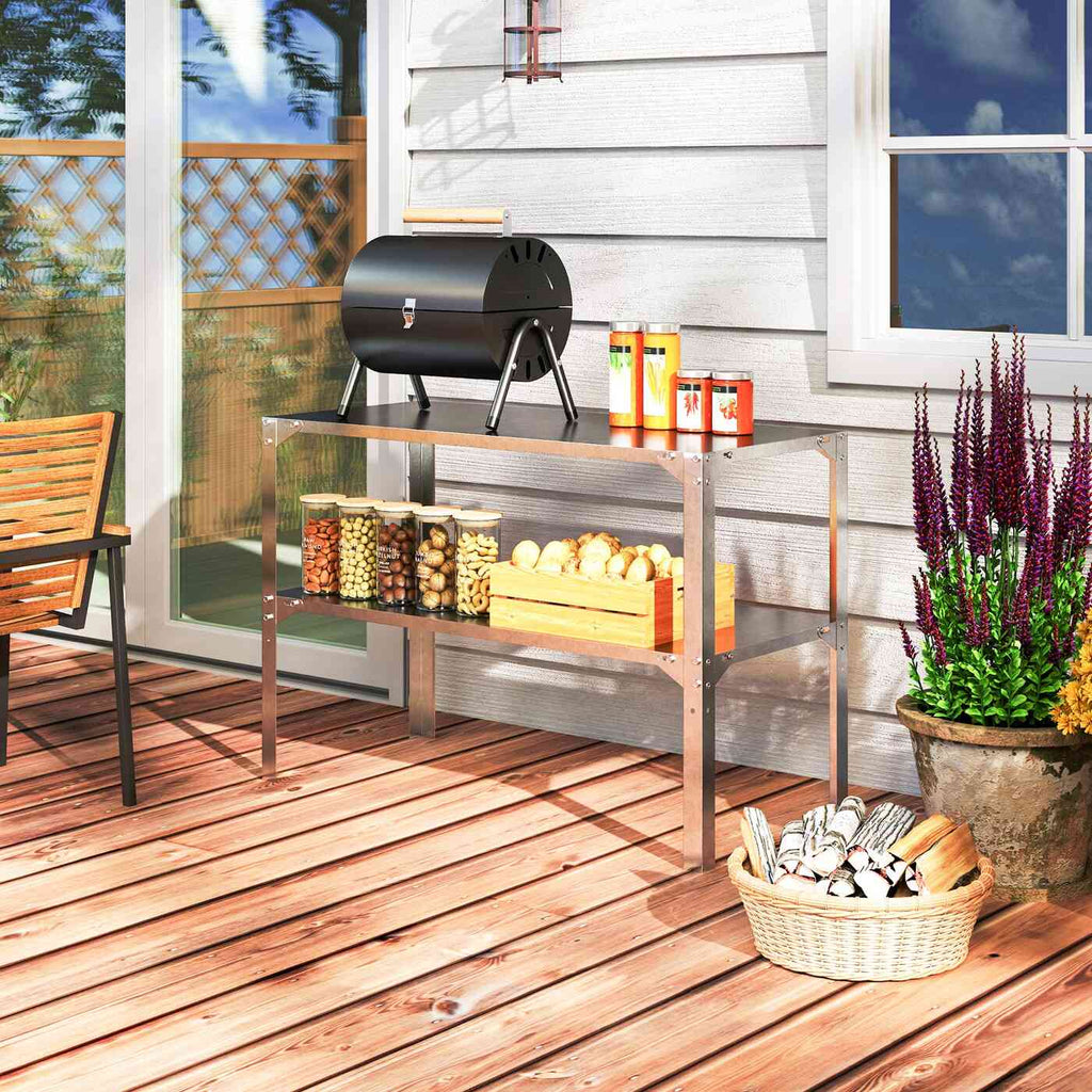 Table métallique utilisée avec un petit barbecue et des accessoires sur une terrasse