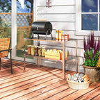 Table métallique utilisée avec un petit barbecue et des accessoires sur une terrasse