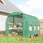 Serre tunnel verte avec étagères de plantes devant une maison