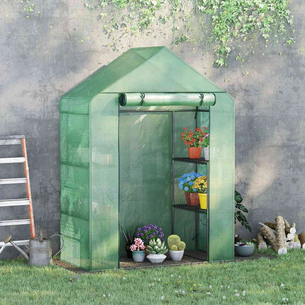 Petite serre verte au jardin avec pots sur ses étagères