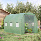 Serre tunnel verte avec cultures devant un abri de jardin