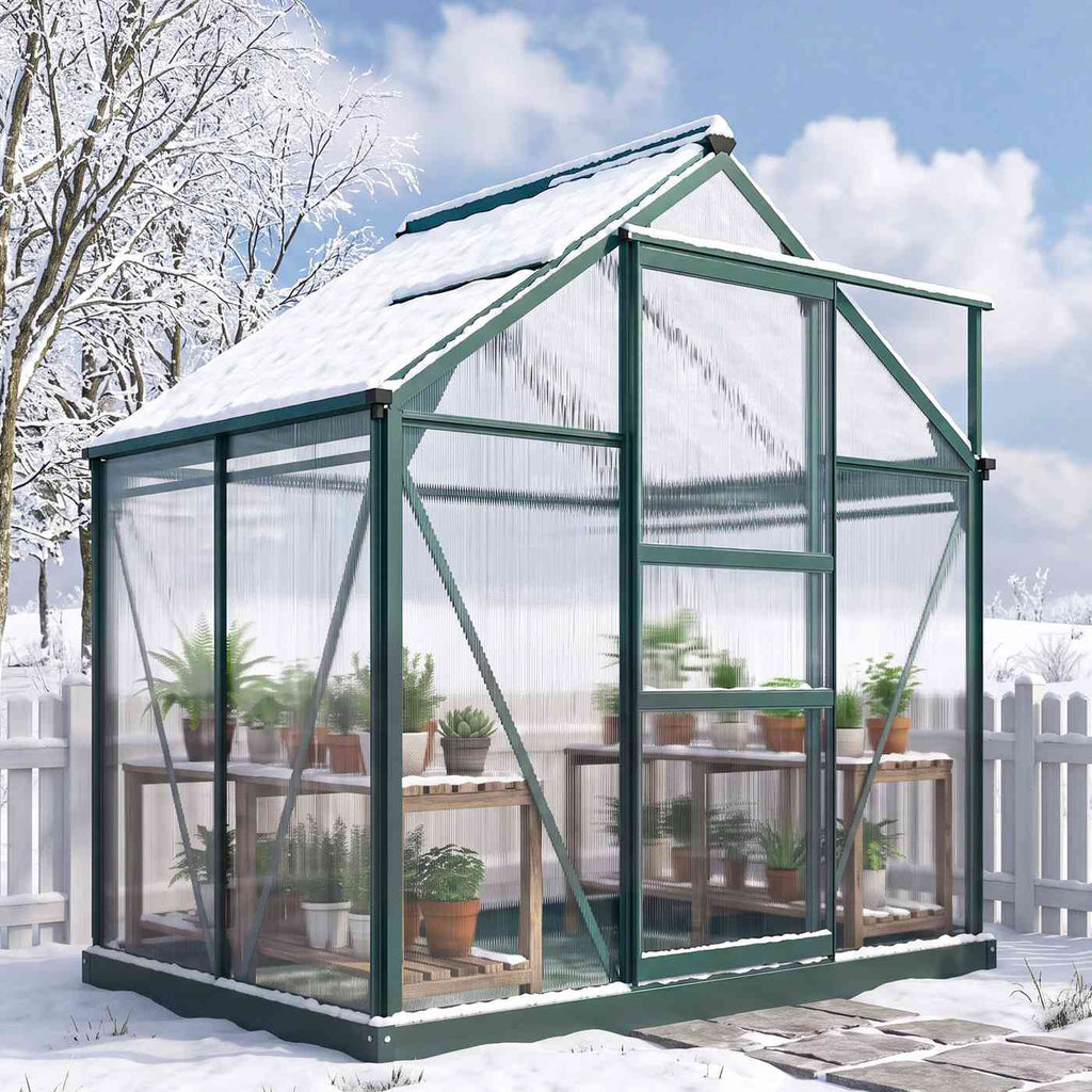 Serre vert foncé avec plantes installée dans un jardin enneigé
