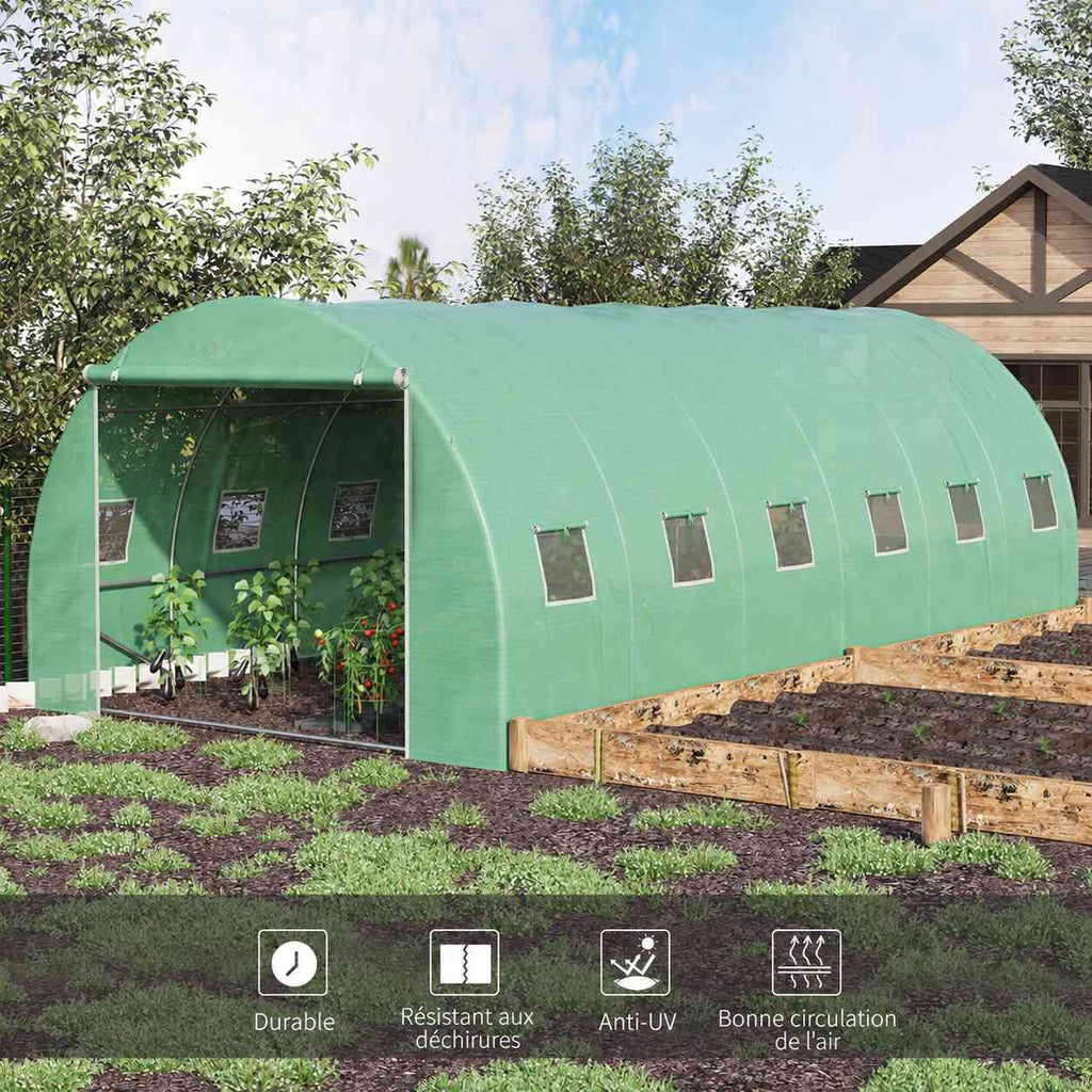 Serre tunnel verte installée sur un potager avec porte ouverte