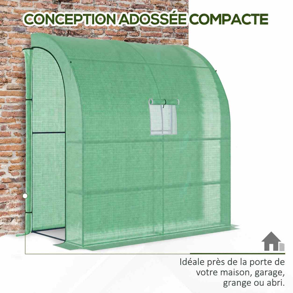 Serre verte arrondie installée contre un mur en briques