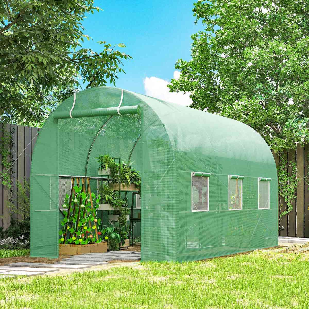 Serre tunnel verte au jardin avec plants de légumes à l’intérieur