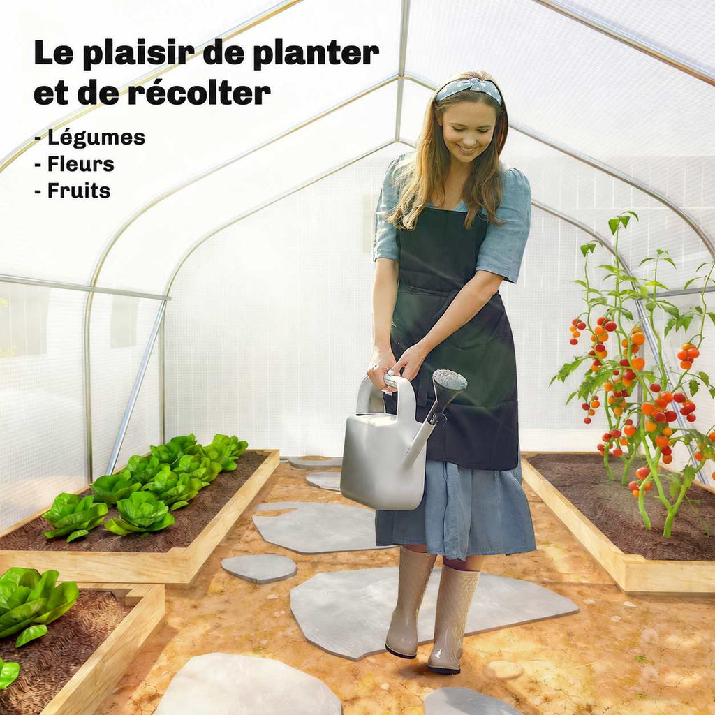 Personne arrosant des plantes dans la serre tunnel blanche