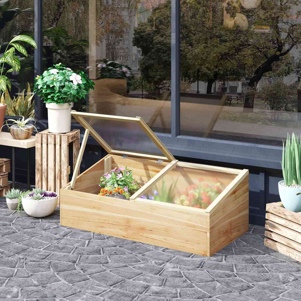 Châssis de culture en bois sur une terrasse avec plantes à l’intérieur