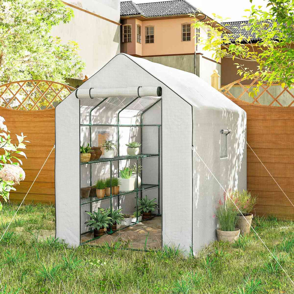 Serre blanche avec plantes près d’un treillage