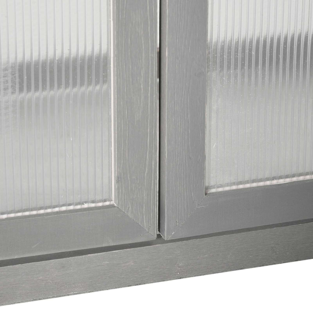 Détail de la base des portes et des panneaux de la serre en bois gris