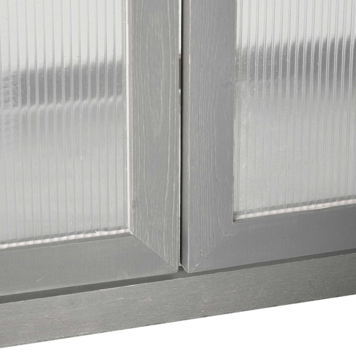 Détail de la base des portes et des panneaux de la serre en bois gris
