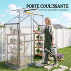 Femme avec un arrosoir devant la porte coulissante ouverte de la serre étroite