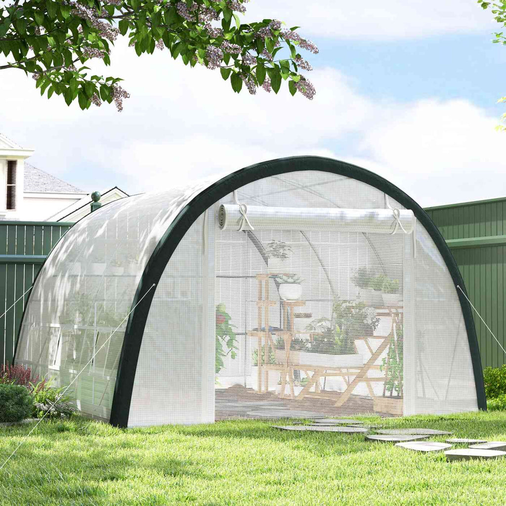Serre tunnel blanche avec plantes et mobilier de jardin à l’intérieur
