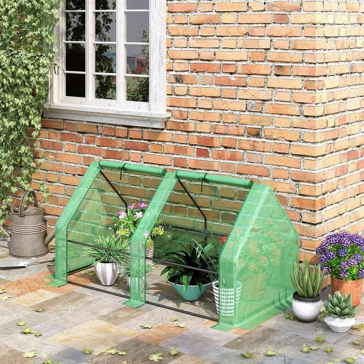 Mini-serre verte installée au pied d’un mur de briques