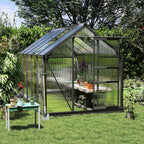 Serre gris foncé au jardin avec une table et des plantes à l’intérieur