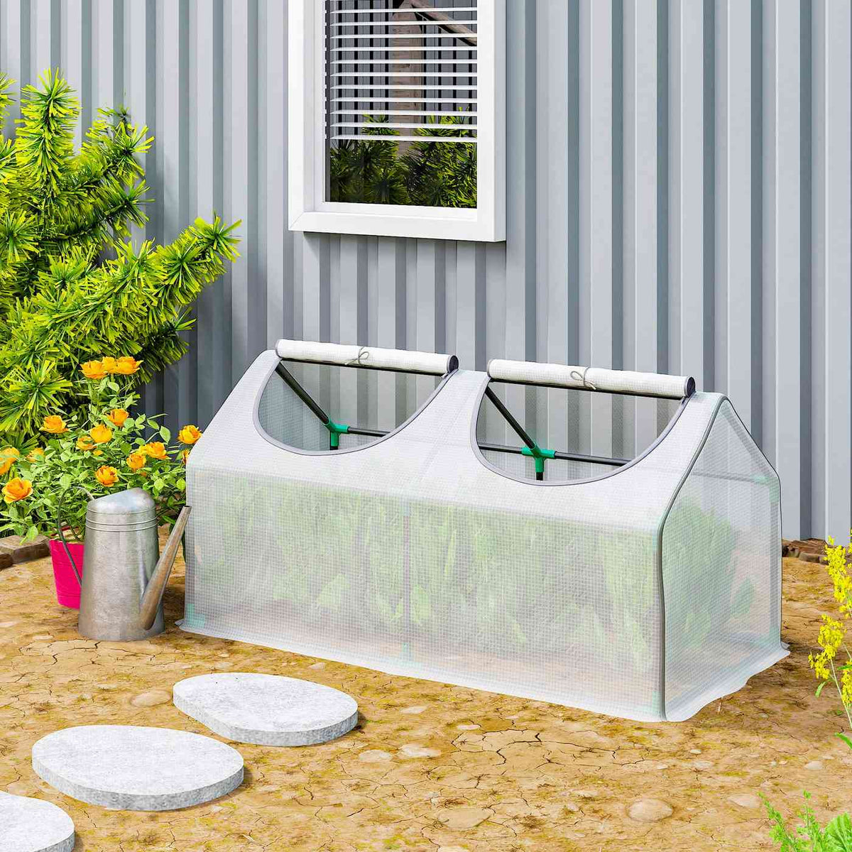 Mini-serre blanche installée devant une façade grise au jardin