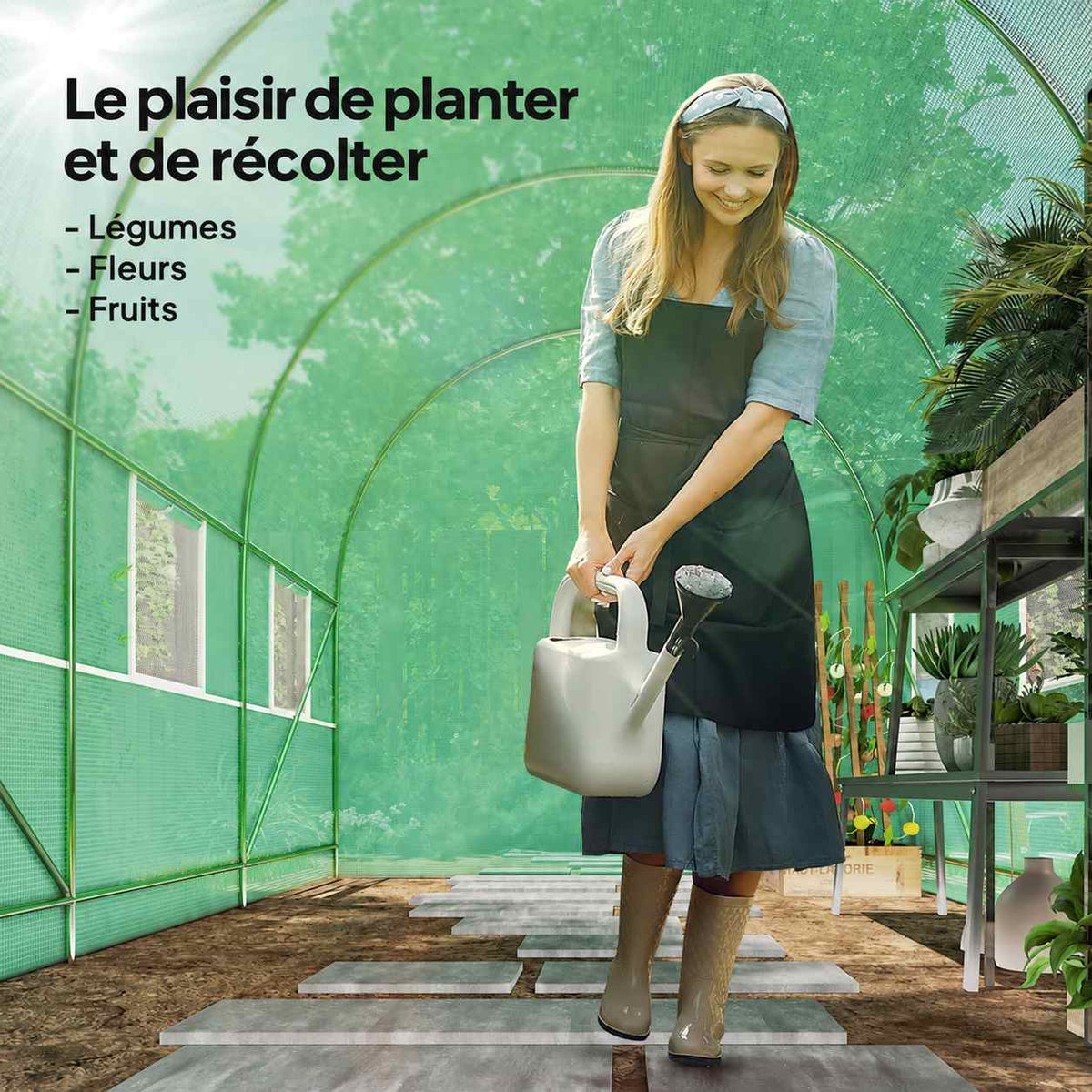 Personne arrosant des plantes à l’intérieur de la serre verte