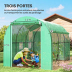 Femme et enfant jardinant dans la serre tunnel verte ouverte