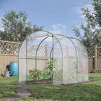 Serre tunnel transparente installée au jardin avec cultures à l’intérieur