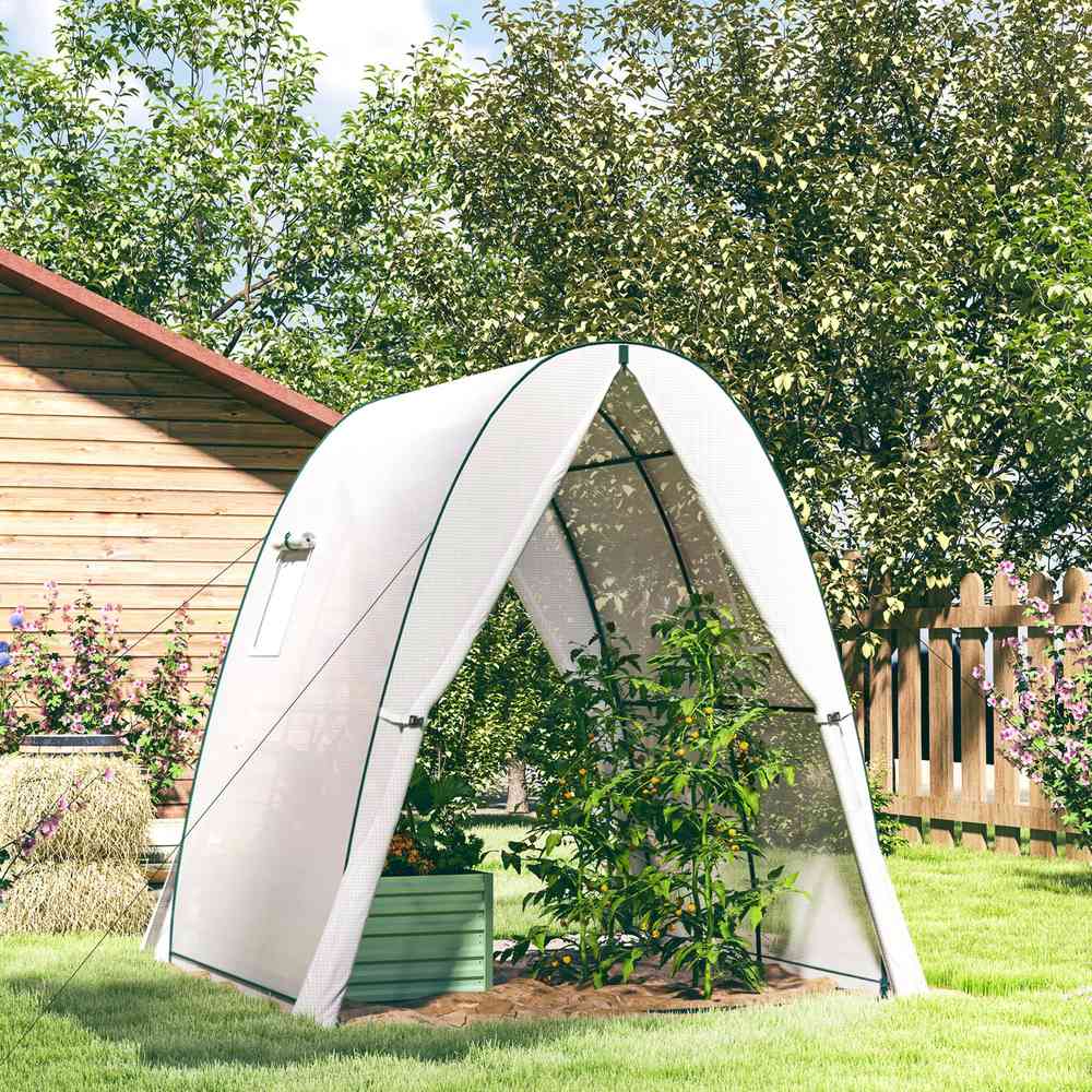 Serre blanche ogivale avec bac potager et plantes dans le jardin