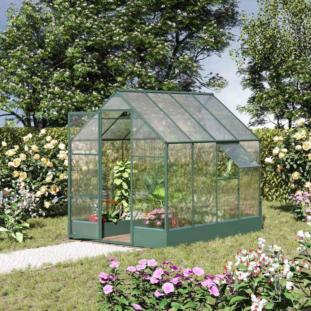 Serre verte aménagée de plantes dans un jardin fleuri