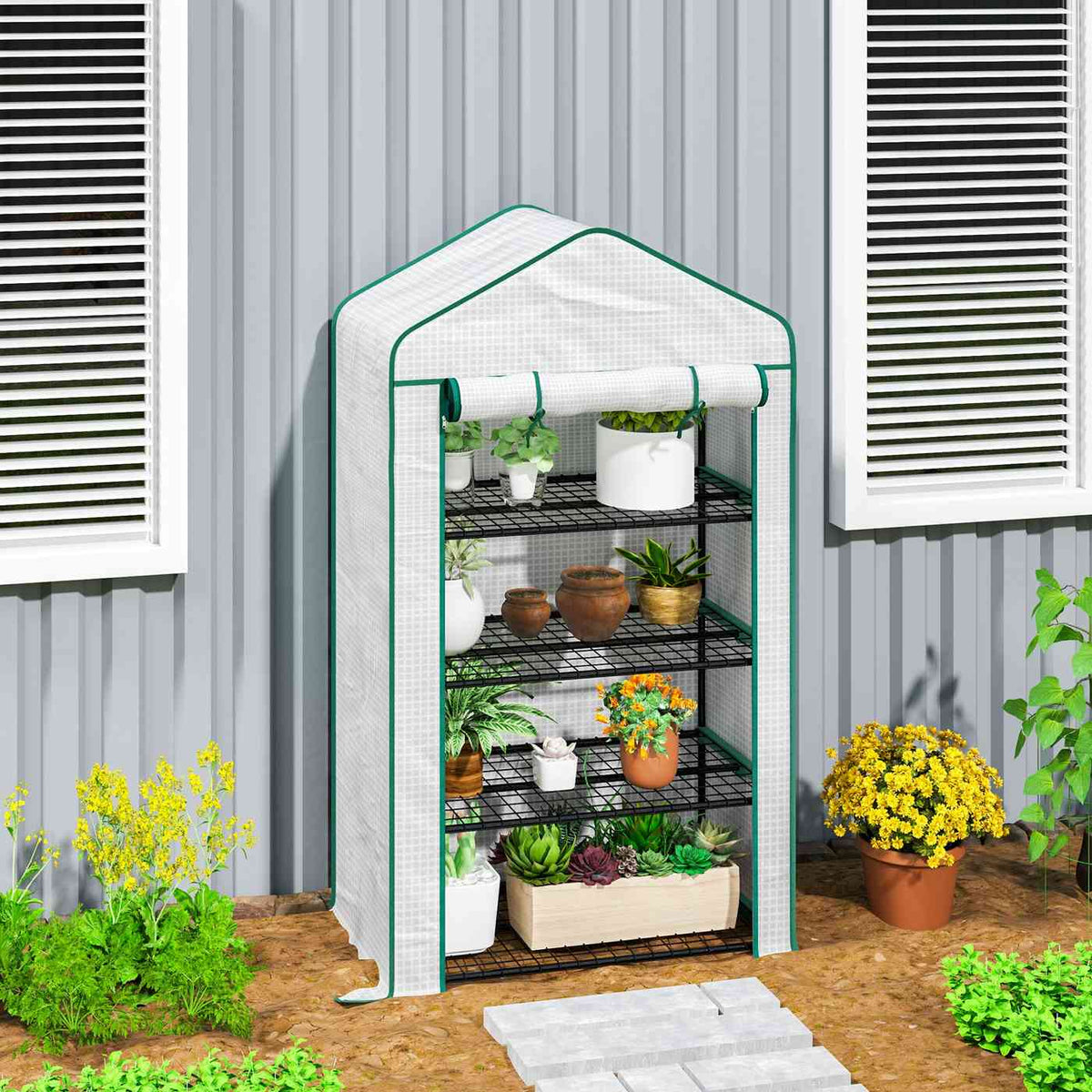 Mini serre blanche avec plantes près d’un bâtiment
