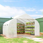 Serre tunnel blanche aménagée d’étagères de plants au jardin
